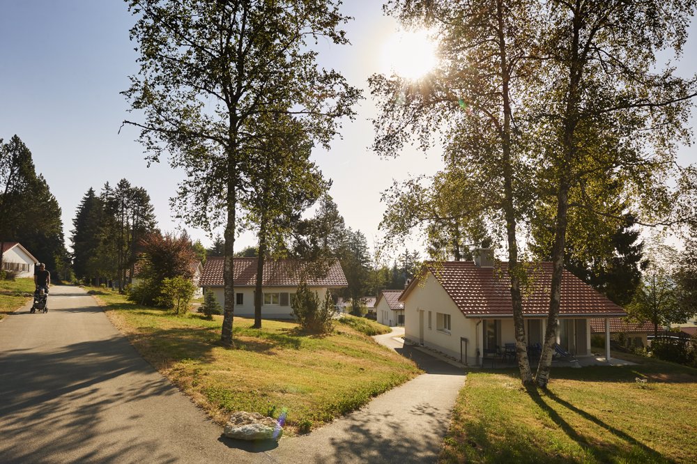 Exterior view in summer - Reka Holiday Village Montfaucon reka-holiday-village, montfaucon, western-switzerland Exterior view in summer - Reka Holiday Village Montfaucon reka-holiday-village, montfaucon, western-switzerland